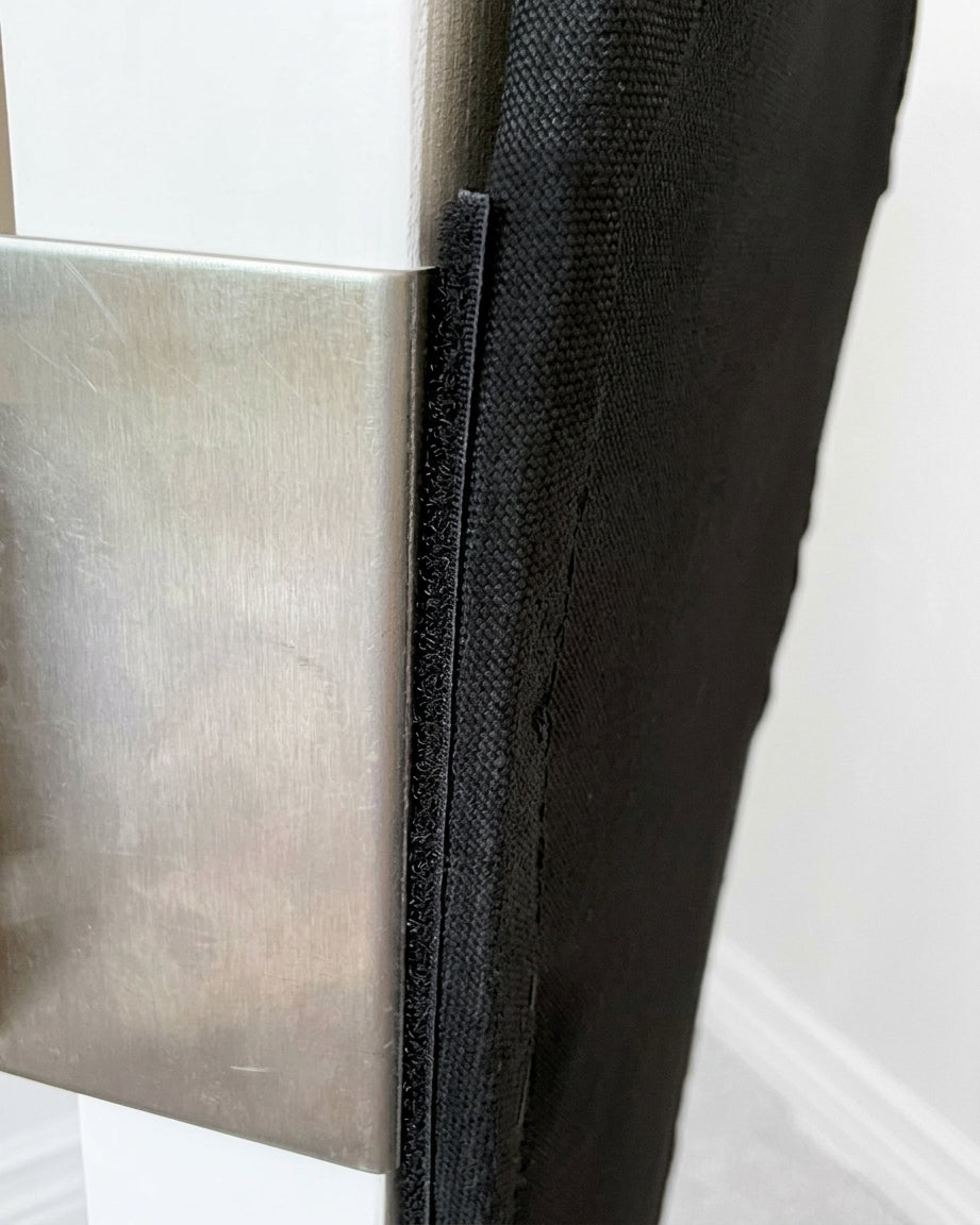 Clawstopper stainless steel clamp gripping the door edge, with the fabric panel attached by hook-and-loop strip